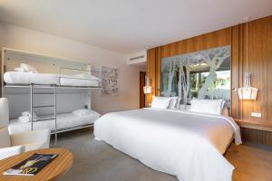 um quarto com uma grande cama branca e beliches em Onyria Marinha Boutique Hotel em Cascais