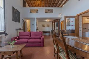 a living room with a purple couch and a table at San Gregorio Magno Apartment in Ferrara