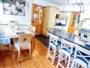 cocina con mesa grande y sillas en Knockmanagh Holiday Home, en Kilcummin