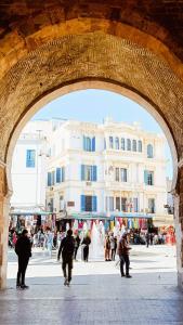 a group of people walking under a stone archway at Hotel Marhaba - Beb Bhar Tunis in Tunis