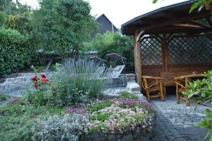 um jardim com um banco e um gazebo em Das Pautzen Haus 