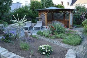 a garden with two chairs and a gazebo at Das Pautzen Haus 