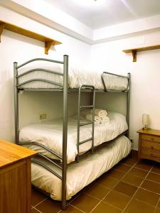 two bunk beds in a room with a desk at Apartamento La Visera Plaza Andalucía in Sierra Nevada