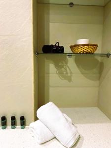 a bathroom with a shelf with towels and a basket at Apartamento La Visera Plaza Andalucía in Sierra Nevada