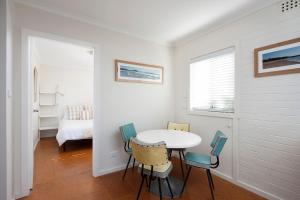Habitación blanca con mesa y sillas en Vitamin Sea, en Mollymook