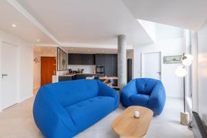 a living room with a blue couch and a table at LA MANUFACTURE - Bel Appartement Contemporain en Coeur de ville in Annecy