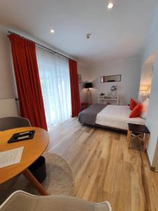 1 dormitorio con cama, escritorio y mesa en Hotel de la Gaichel, en Eischen