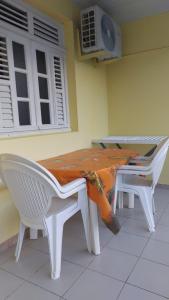 mesa y 2 sillas con mesa y ventana en La villa du manguier, en Le Vauclin