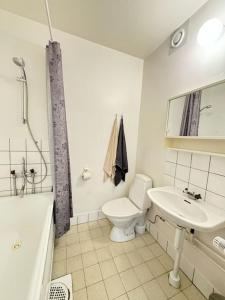 ein Badezimmer mit einem WC, einem Waschbecken und einer Badewanne in der Unterkunft Lägenhet i centrala Lidköping - MyHostel in Lidköping