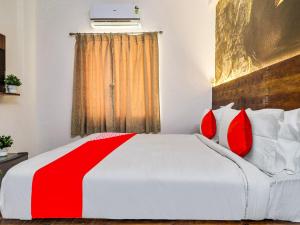 海得拉巴的住宿－Super OYO Flagship Big Daddy Suites，卧室配有带红色枕头的大型白色床