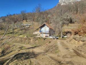 ein Haus auf einem Hügel mit einer unbefestigten Straße in der Unterkunft Mountain Home Paravci in Čajniče