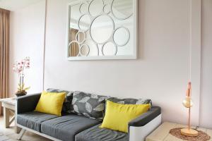 a living room with a gray couch and yellow pillows at Breakers 419 by Top Destinations Rentals in Durban