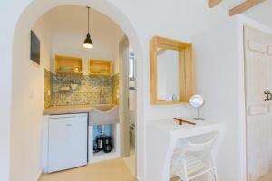 a white kitchen with a sink and a counter at Ampelos Plaka in Plaka