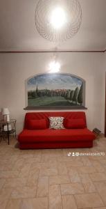 un sofá rojo en una habitación con una pintura en la pared en ANTICO BORGO, en Santa Maria a Monte