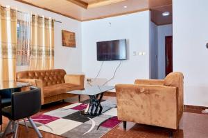 Becky Best Apartments في يمبي: غرفة معيشة مع أريكة وطاولة