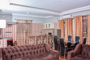 Becky Best Apartments في يمبي: غرفة معيشة مع أريكة وطاولة مع كراسي