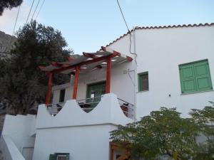 ein weißes Gebäude mit grüner Tür und Balkon in der Unterkunft zacharoularooms3 in Manganítis