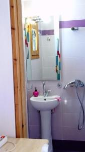 ein Bad mit einem Waschbecken und einem Spiegel in der Unterkunft zacharoularooms3 in Manganítis