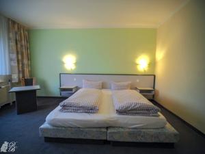 a bedroom with a large bed with two pillows at Hotel und Restaurant Harzparadies in Harztor