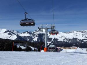 a ski lift with people on it in the snow at Familienfreundliches Apartmenthaus Thuss`n, ruhige Lage, im Herzen der Wanderregion Kitzbüheler Alpen und MTB Trails in Kirchberg in Tirol