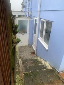 alejka z niebieskim budynkiem i drzwiami w obiekcie Kinterbury Annexe w mieście Plymouth