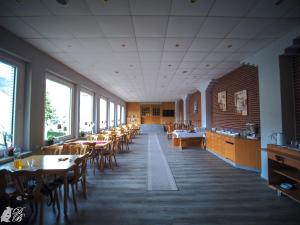 a dining room with tables and chairs and windows at Hotel und Restaurant Harzparadies in Harztor