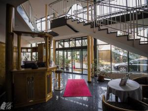 a lobby with a staircase and a pink rug at Hotel und Restaurant Harzparadies in Harztor