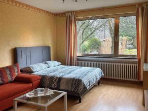 エンゲルスキルヒェンにあるVilla Engelskirchenのリビングルーム(ベッド1台、ソファ、窓付)