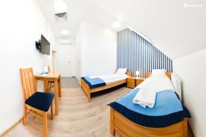 een kamer met 2 bedden en een tafel en een stoel bij Marina Grudziądz in Grudziądz