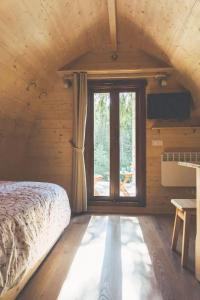 a bedroom with a bed and a large window at International Camping Olympia in Maion