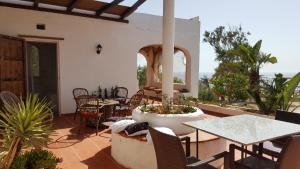 a patio with a table and chairs and a large planter at Villa Jeko in Lampedusa