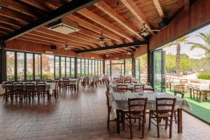 a dining room with tables and chairs and windows at Village Lake Placid in Silvi Marina