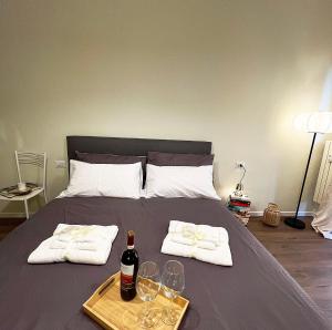ein Bett mit einer Flasche Wein und Gläsern darauf in der Unterkunft Lawyer House Milan in Mailand