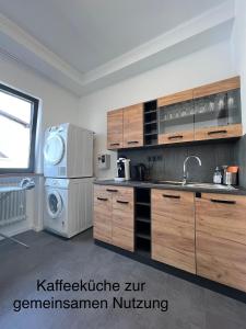 cocina con nevera, lavadora y secadora en Komfortable Monteurwohnung in Weiskirchen, en Weiskirchen