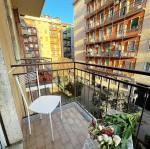 einen Balkon mit einem weißen Stuhl und Blumen auf dem Balkon in der Unterkunft Lawyer House Milan in Mailand