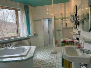 a bathroom with two sinks and a tub and a shower at Villa Engelskirchen in Engelskirchen