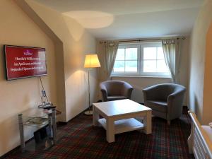 a living room with two chairs and a table at Ferienhof Spreewaldromantik in Burg