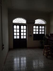 an empty room with two windows and a door at Mr. Hợp in Kim Côn