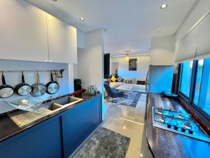 uma cozinha com armários azuis e uma sala de estar em Villa Alambra Marrakech sur Atlas, Piscine privée em Marrakech