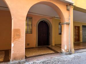 un arco que conduce a un edificio con una puerta negra en Bologna Sweet Home, en Bolonia