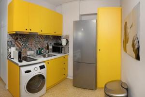 een keuken met gele kasten en een koelkast bij Crown Syntagma Apartment in Athene