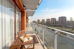 a balcony with a table and a view of a city at Downtown Apartments Aura - Riverside & Parking in Gdańsk