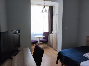 um quarto com uma cama, uma televisão e uma mesa em Polonia em Międzyzdroje