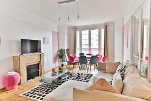 a living room with a couch and a fireplace at Appartement Luxueux Porte Maillot - Neuilly - III in Neuilly-sur-Seine