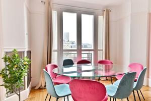 uma sala de jantar com uma mesa de vidro e cadeiras em Appartement Luxueux Porte Maillot - Neuilly - III em Neuilly-sur-Seine