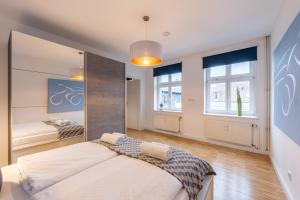 a bedroom with a large bed and two windows at Elflein Quartier in Potsdam