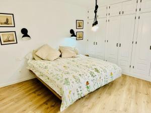 een bed in een slaapkamer met witte muren en houten vloeren bij Luxury Bungalow Playa Roca in Costa Teguise