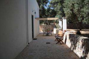 a patio with chairs and a table and an umbrella at Masseria Trotta B&B in Fasano