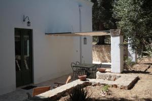 a patio with a table and a large umbrella at Masseria Trotta B&B in Fasano