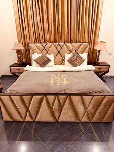 a bedroom with a large bed with a wooden headboard at Reina Boutique Hotel - G9 in Islamabad